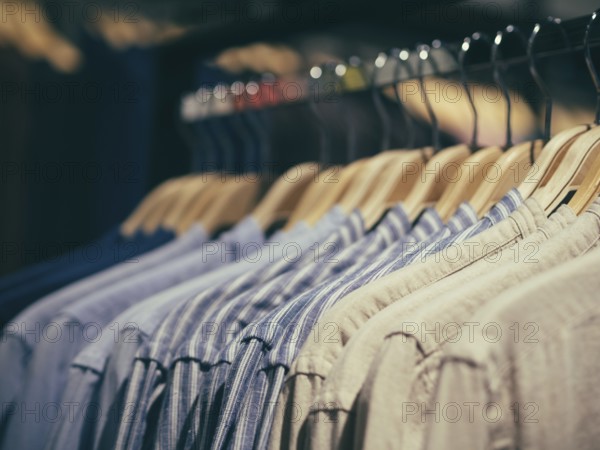 Close up view of man clothes hang in clothes store. Hangers with different male clothes. Copy space