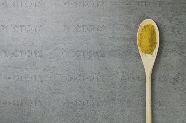 Turmeric spice in wooden spoon