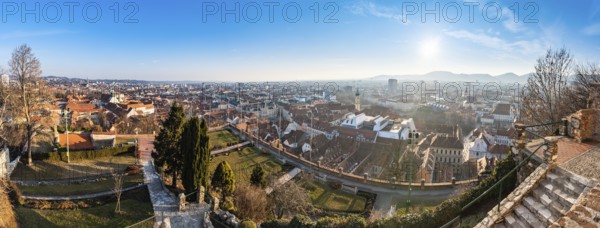 Wide panorama of Graz City, City rooftops, Mur river and city center, Schlossberg hill and clock