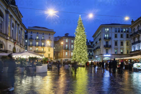 Amazing view on Christmas tree in Lugano on Reformation Square, blurred motion people Cafes