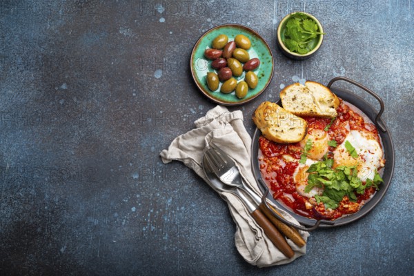 Middle Eastern and Maghrebi healthy dish Shakshouka made of eggs and tomato sauce served in pan