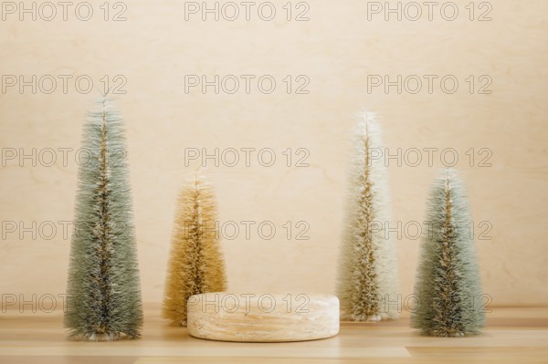 Wooden podium pedestal product mockup display with miniature Christmas trees in beige and green, 3d