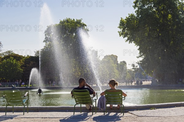 Paris, France, September 3, 2018: A man and a woman are resting by the pond in the Tuileries garden