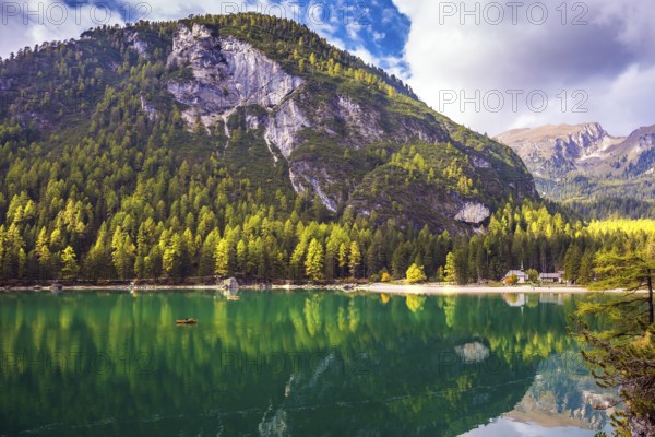 Magnificent lake Lago di Braies. Emerald expanse of water reflects the surrounding forest and