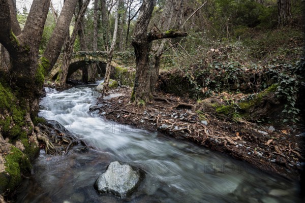 Beautiful medieval stoned bridge or Milia with river full with water flowing at Troodos mountains