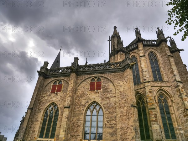 Gothic brick church with high windows and a dramatic, cloudy sky, Xanten, North Rhine-Westphalia,