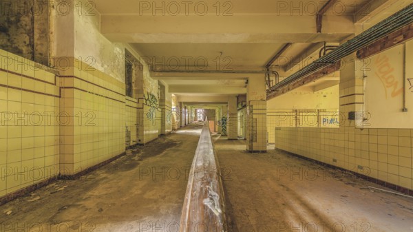 Long abandoned corridor with tiled walls and graffiti, industrial decay, Preventorium Dolhain, Lost