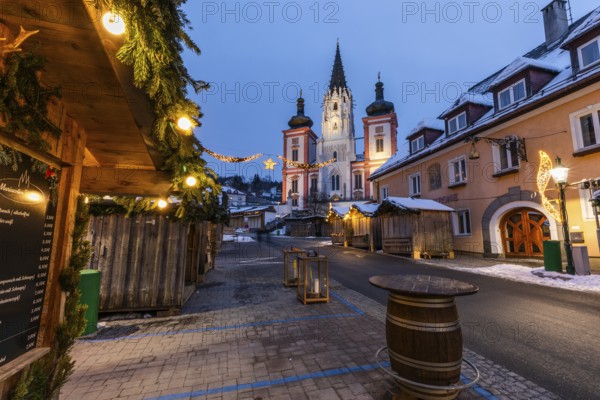 Advent atmosphere, street illuminated for Christmas, facade of the basilica behind, blue hour in