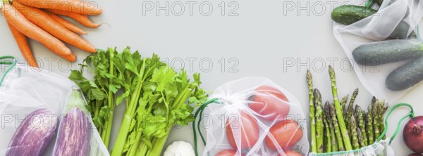 Fresh organic vegetables in eco reusable produce shopping bags flat lay, top view with copy space