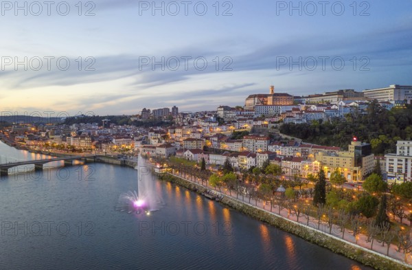 Coimbra drone aerial city view at sunset with colorful fountain in Mondego river and beautiful