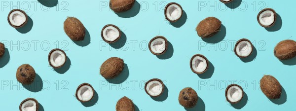 Creative layout of coconuts half on blue background. Tropical pattern, top view or flat lay. Hard