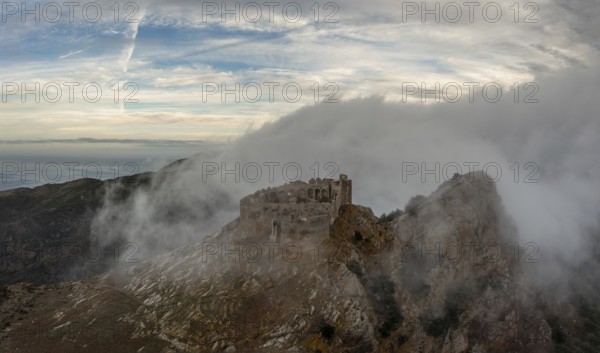 Magazzini, Italy, 14 November, 2023: drone view of the Castello del Volterraio shrouded in morning