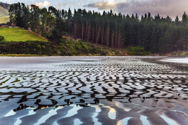 Sunrise over the ocean. Low tide. Strips of sand and water left by the ocean tide. The art of