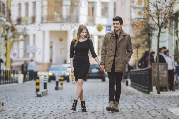 Urban modern young love couple walking romantic talking talking, holding hands on a date. Young