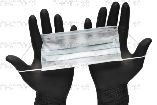 Medical man holds antivirus face mask in hands in black medical gloves. Isolated on white