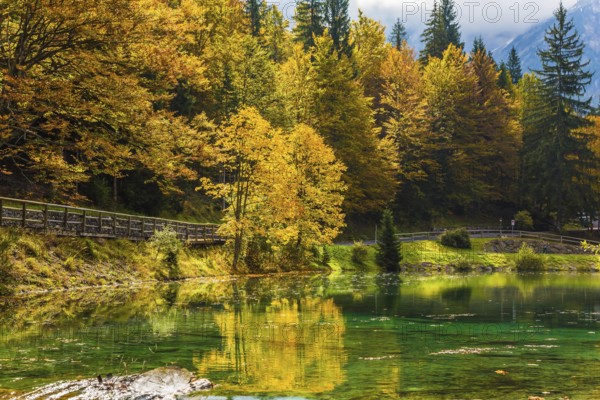 Fantastically beautiful autumn forests are reflected in the water. The quiet lake in Northern