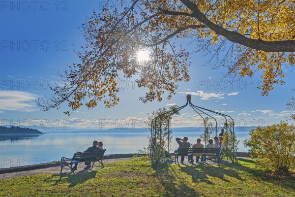 Park benches with visitors in the autumnal spa gardens, Herrsching am Lake Ammer, Upper Bavaria,