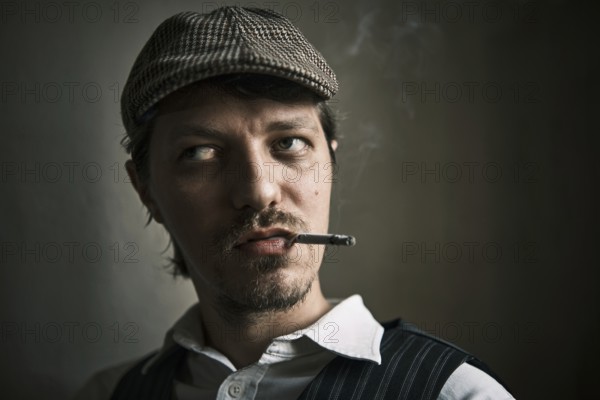 Young guy smoking cigarette, blows smoke, dressed in a retro style, in a beret, cinematic shot, big