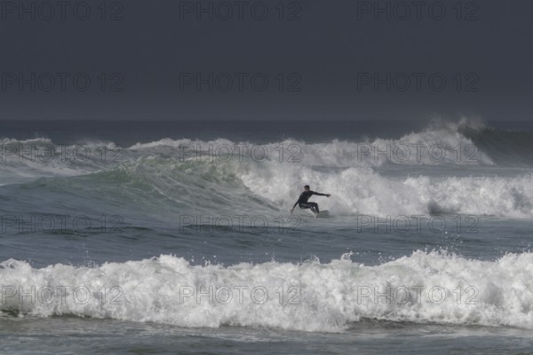 Sidi Ifni, Morocco, 17 March, 2024: man surfing a large wave off the coast of southern Morocco in
