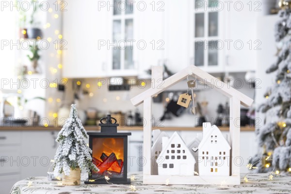 Key and tiny house of a small size on cozy home with Christmas decor on table of festive white