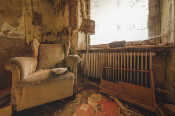 An outdated room with armchair and lamp next to a neglected heating system, Lost Place, Urologist's