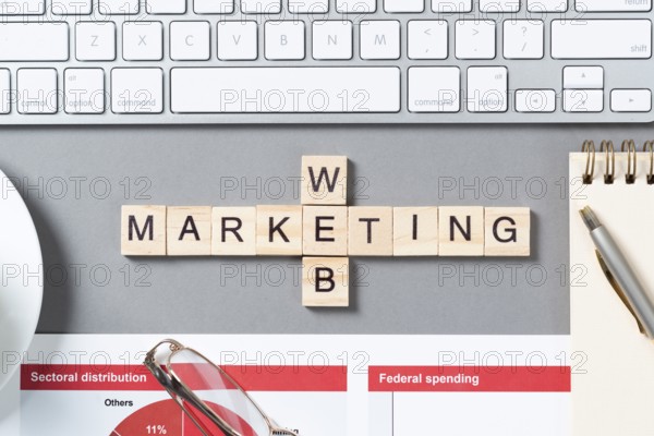Web marketing concept with letters on cubes. Still life of office workplace with crossword. Flat