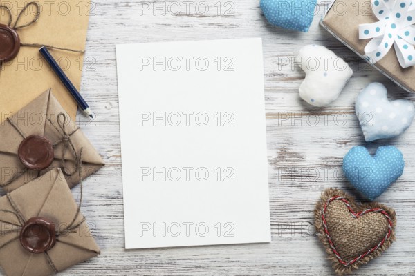 Flat lay cute composition with handmade fabric heart. White paper and retro mail envelopes on