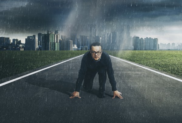 Young businessman starting position to his career with city skyline background, raining day .