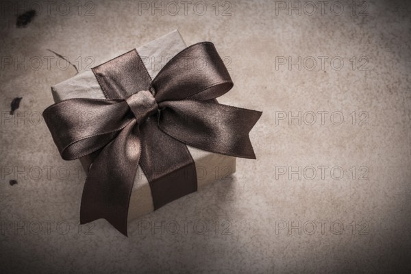 Present box with tied bow paper on vintage background