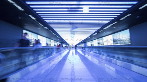 People going in walkway and riding flat escalators at the airport of Seoul, South Korea. Futuristic