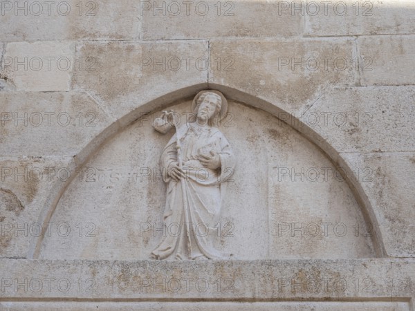 Stone relief on church façade, figure of a saint, old town centre of Korcula, island of Korcula,
