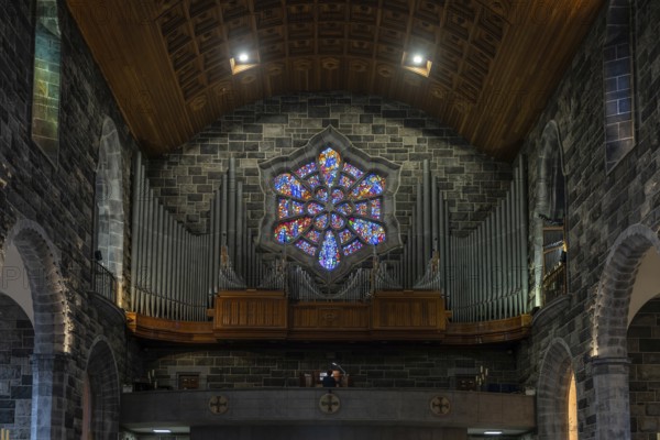 Galway, Ireland, 28 July, 2022: close-up view of the organ and stained glass window in the nave of