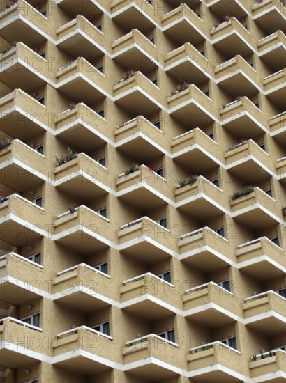 Large highrise modern apartment building with large number of repeating geometric balconies in