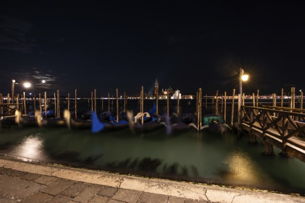 Venetian gondolas, boat dock at St Mark's Square, church of San Giorgio Maggiore in the background,
