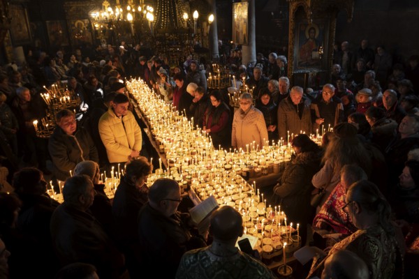 Blagoevgrad, Bulgaria - February 10, 2019: Worshippers light candles on jars with honey during a