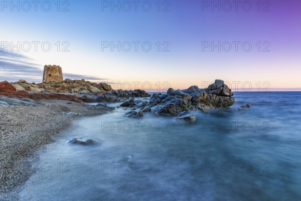 Old historic tower from the 16th century and rocks at sunset on the beach, long exposure, Torre di