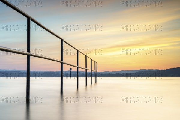 Railing in the lake in the warm light of the sunset, quiet atmosphere, lido, Litzelstetten, Lake