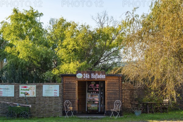 Wooden hut with a vending machine for sausage and cheese in a 24-hour farm shop, village of Rieben