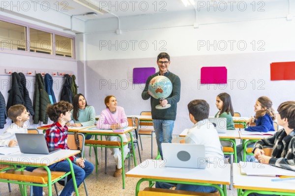 Geography teacher engaging students while holding a globe, fostering learning and understanding in