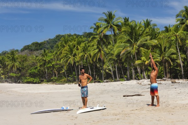 Surfers warming up on the beach of Santa Teresa, Nicoya Peninsula, Guanacaste, Costa Rica, Central