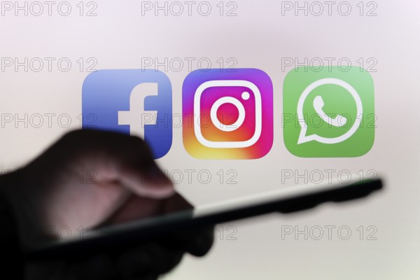 In this photo illustration the Facebook, Instagram and WhatsApp logo app seen in the background of
