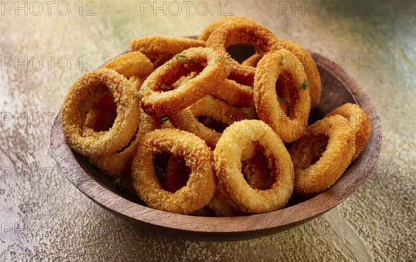 Deep fried onion rings, appetizer, with tomato sauce, on a wooden plate, without people, favorite