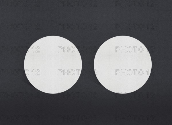 Two white circular papers symmetrically placed on a dark background, Blank white Business card