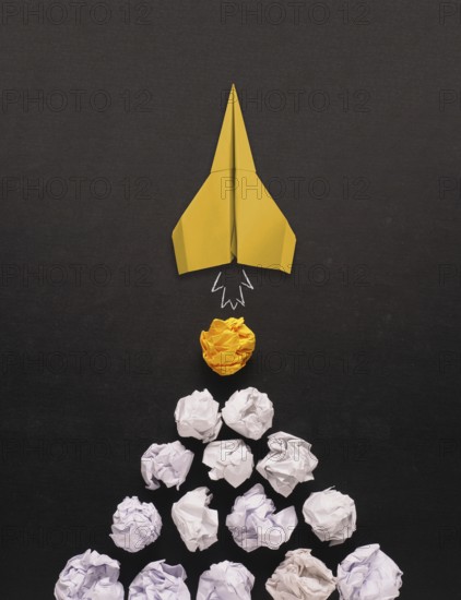 Launching paper rocket with jet stream of paper balls, creativity concept or new ideas metaphor,