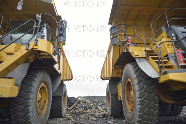 Two 130 ton tiptrucks waiting for work at an open cast coal mine, Westland, New Zealand, Oceania