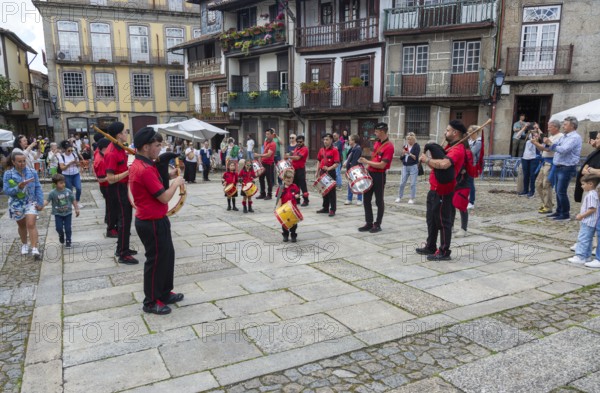 Traditional drum and pipe band perform on city streets on May Day 2025, Guimaraes, Braga district,
