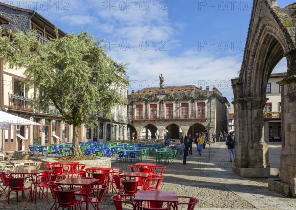 Tables and chairs, historic buildings in Largo da Oliveira square, city of Guimaraes, northern
