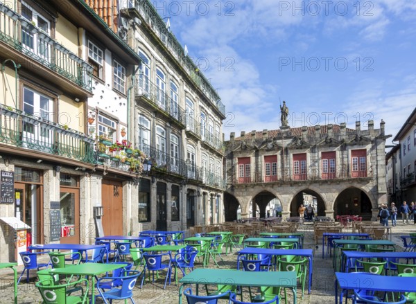 Tables and chairs, historic buildings in Largo da Oliveira square, city of Guimaraes, northern