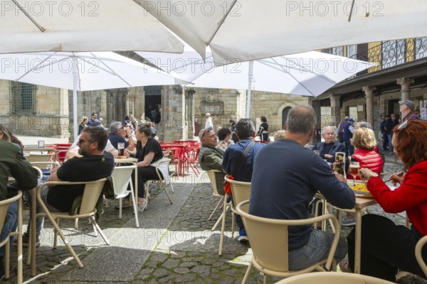 Customers sittimg outside at cafe tables, Largo da Oliveira square, city of Guimaraes, northern