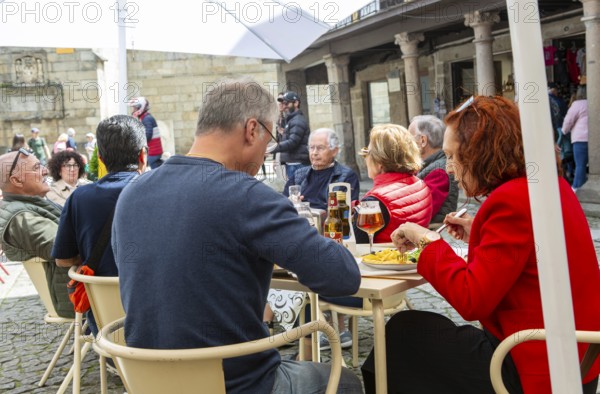 Customers sittimg outside at cafe tables, Largo da Oliveira square, city of Guimaraes, northern